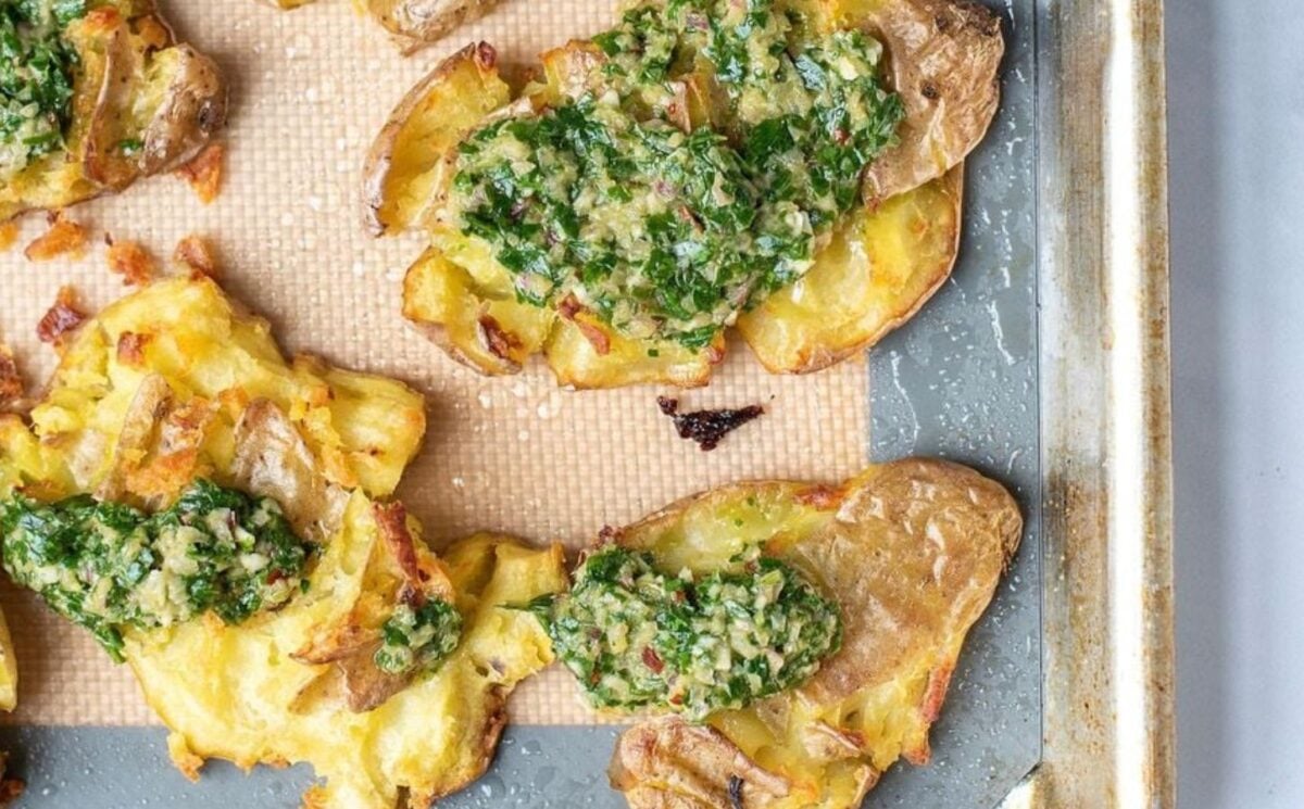 smashed whole potatoes covered in garlic and chimichurri sauce