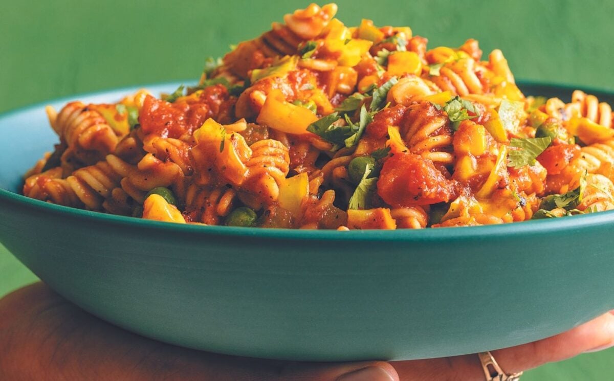 a vegan pasta made with Indian spices, chili, garlic, bell peppers, tomato, coconut milk, nutritional yeast, and vegan cheese