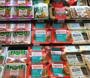 A selection of vegan meat next to animal meat at the supermarket