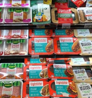 A selection of vegan meat next to animal meat at the supermarket
