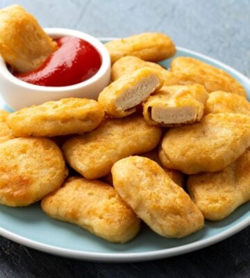 A plate full of vegan chicken nuggets with a pot of tomato ketchup