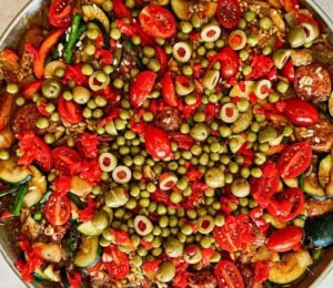 vegan Spanish paella filled with rice, saffron, olives, beans, beyond sausage, and lots of vegetables