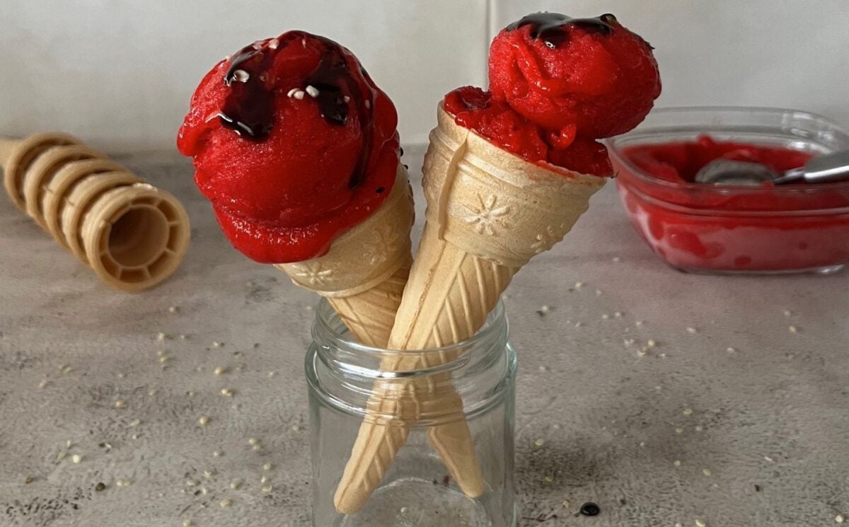 a picture of two ice cream cones topped with vegan 3-ingredient strawberry ice cream