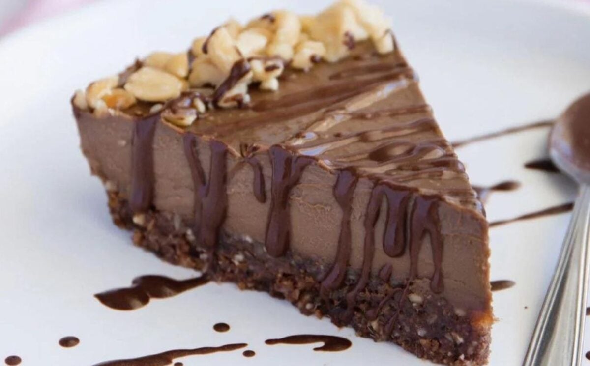 a slice of vegan chocolate avocado cheesecake with a drizzle of chocolate and a nut base