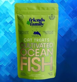 A packet of cat food made from cultivated fish in front of a navy blue patterned background
