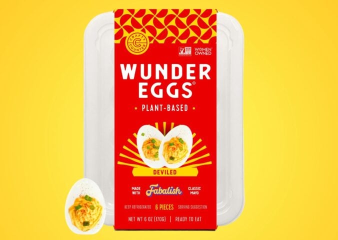 A pack of vegan deviled eggs in front of a bright yellow background