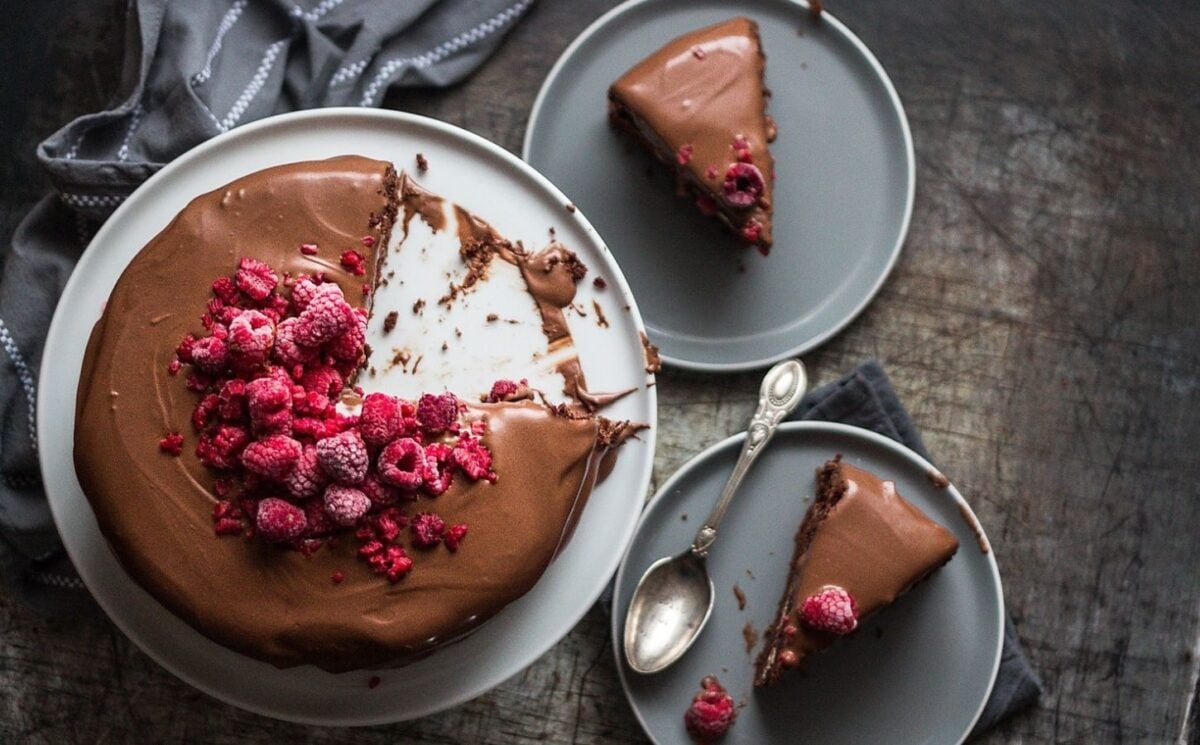 a vegan double chocolate cake with marshmallow filling, topped with raspberries