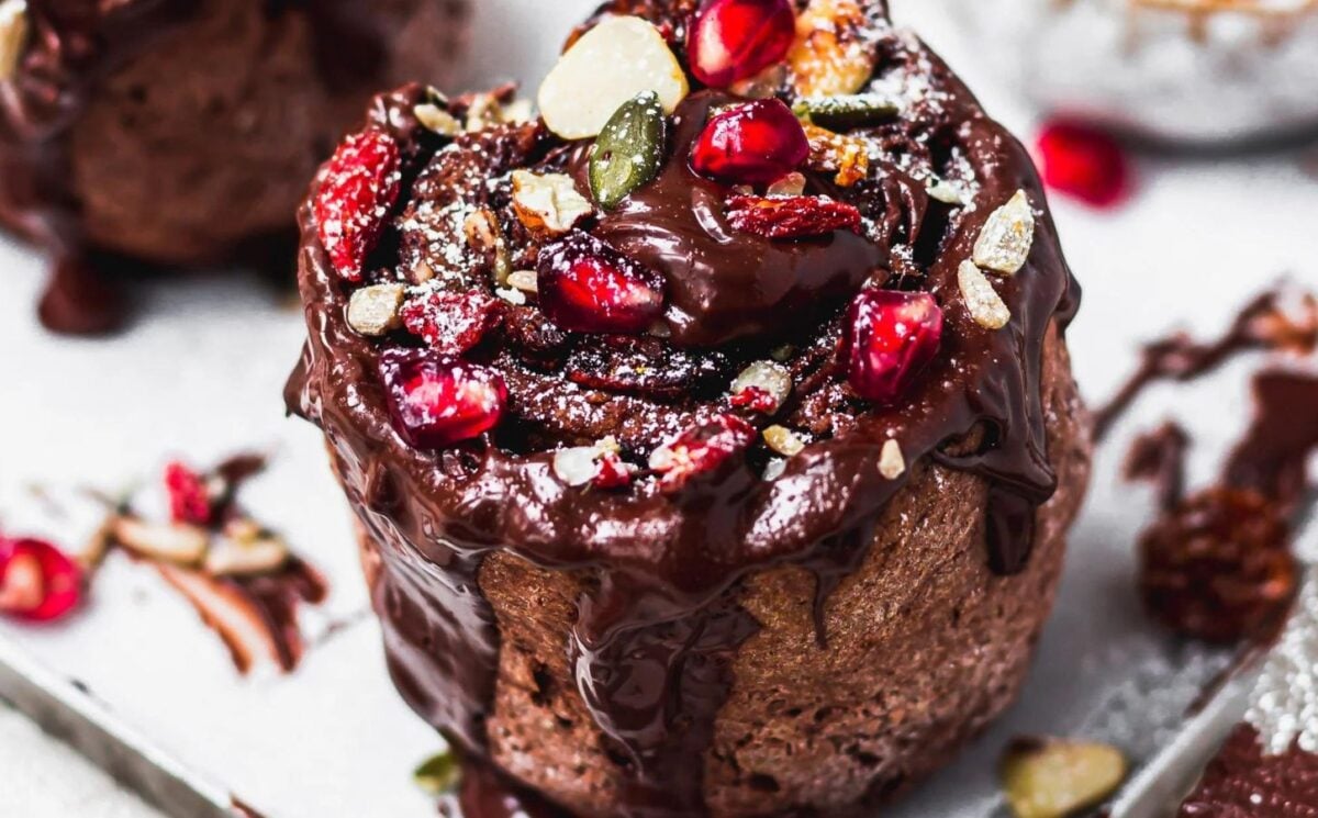 a vegan double chocolate fruit and nut swirl rolls covered in chocolate and pomegranate seeds