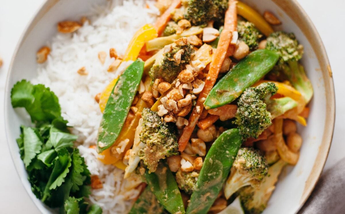 a picture of a vegan 15-minute peanut butter stir fry made with mange tout, broccoli, chickpeas, and yellow pepper