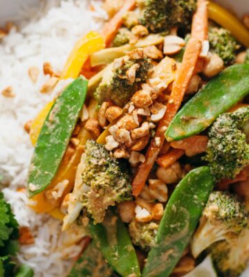 a picture of a vegan 15-minute peanut butter stir fry made with mange tout, broccoli, chickpeas, and yellow pepper