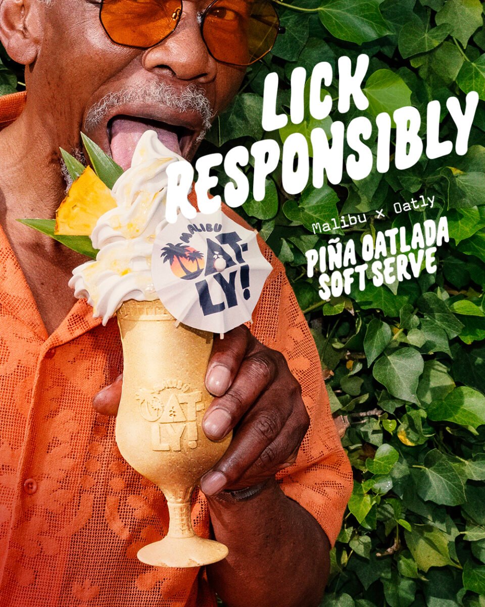 Photo shows a middle-aged Black man in a summery orange shirt holding Oatly and Malibu's new cocktail-inspired alcoholic soft serve, the "Piña Oatlada"