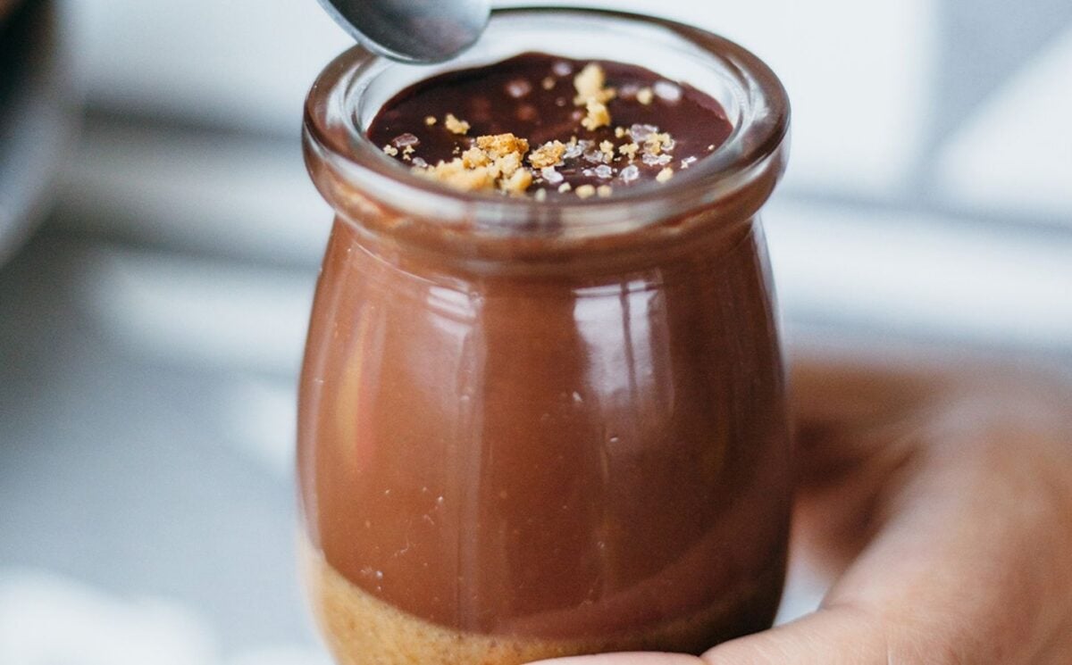 a picture of a salted caramel chocolate pot made with vegan ingredients and topped with salt and biscuits