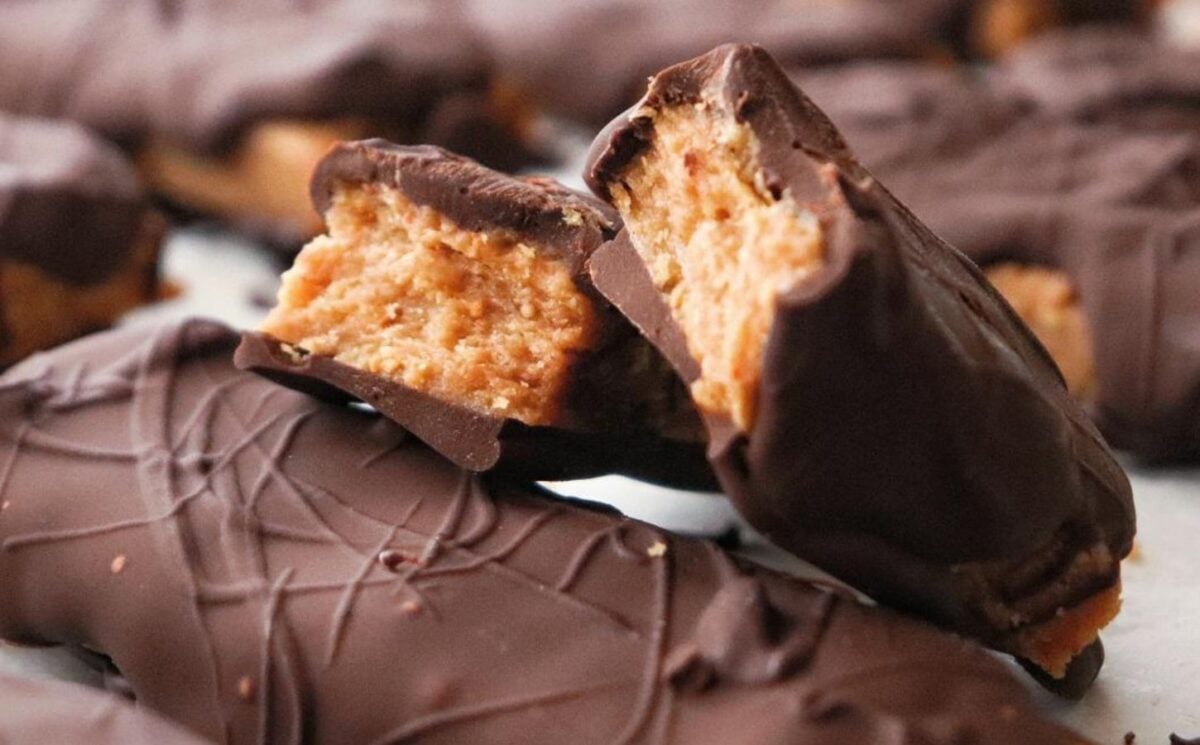 a picture of vegan Butterfinger bars stacked on top of each other coated in vegan chocolate