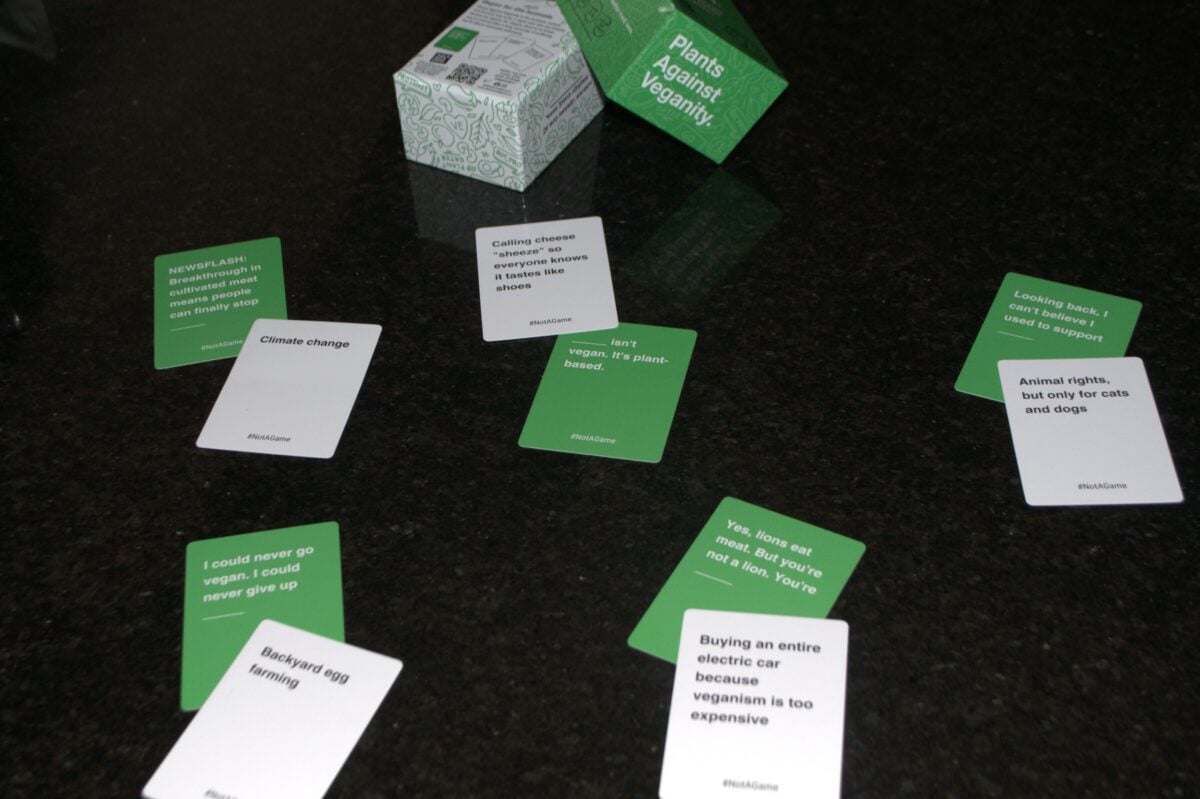 The photo shows some of the cards included in This Is Not A Game. "Plants against veganism" vegan card game