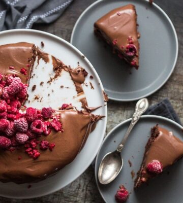 a vegan double chocolate cake with marshmallow filling, topped with raspberries