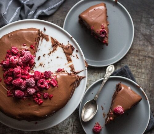 a vegan double chocolate cake with marshmallow filling, topped with raspberries