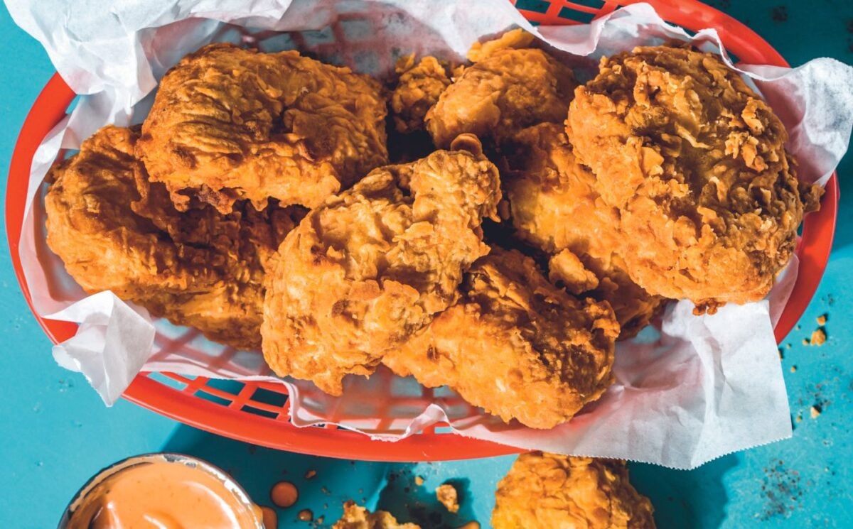 a picture of vegan friend chicken in a basket with sauce on the side