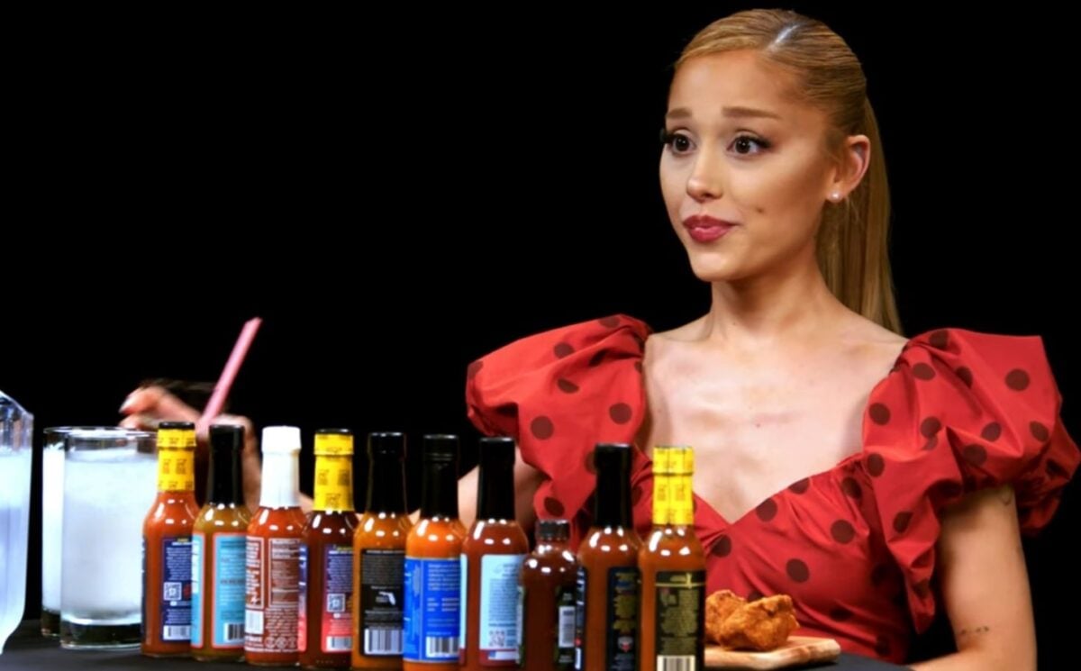 Photo shows Ariana Grande appearing on Hot Ones, where she ate vegan wings