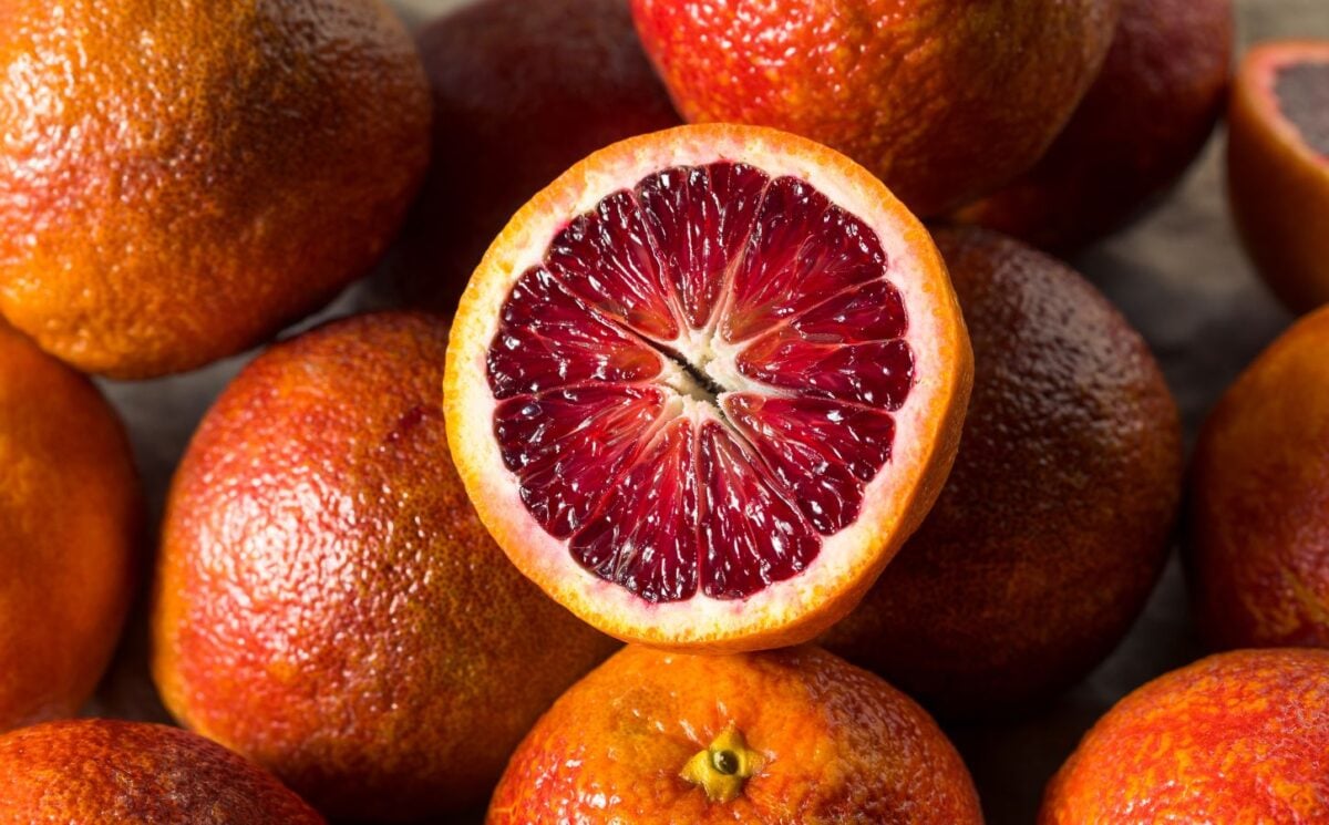 A selection of blood oranges, including a close-up of one split in two