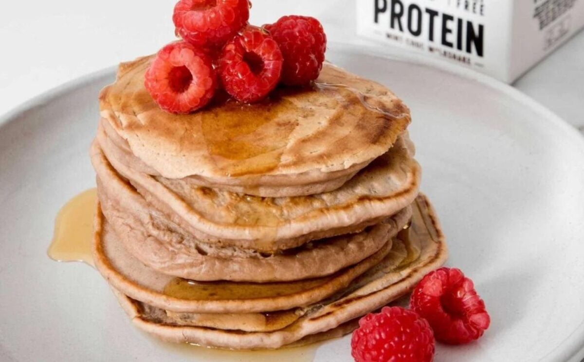 a picture of plant-based protein pancakes made with a vegan protein milkshake and topped with raspberries for a quick high protein breakfast