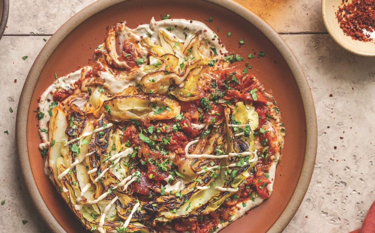 a picture of buttery charred cabbage in spiced tomatoes with tahini