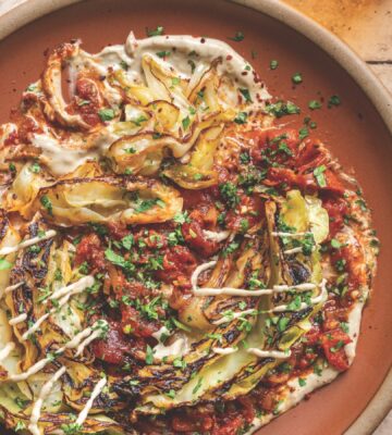 a picture of buttery charred cabbage in spiced tomatoes with tahini