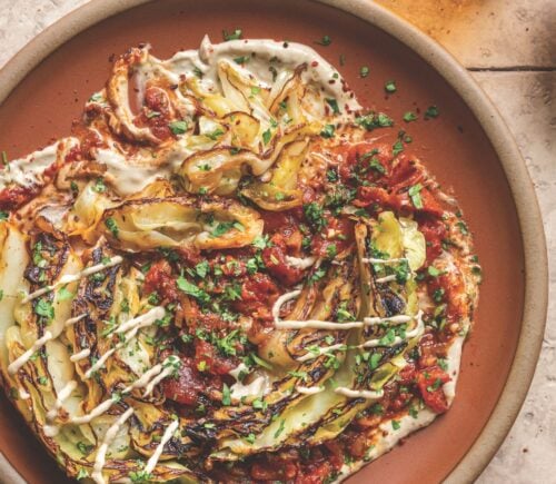 a picture of buttery charred cabbage in spiced tomatoes with tahini