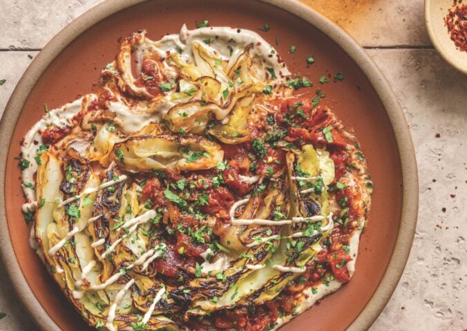 a picture of buttery charred cabbage in spiced tomatoes with tahini