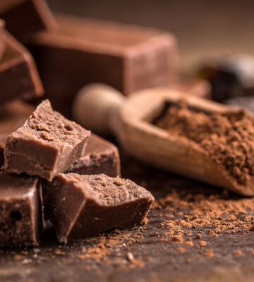 Some homemade chocolate next to some chocolate powder