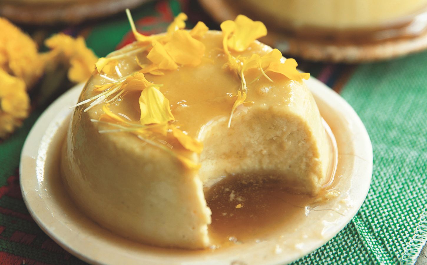 a picture of a vegan coconut flan made with tofu, coconut milk and cream, agar powder, sugar, vanilla, and topped with a syrup and edible flowers