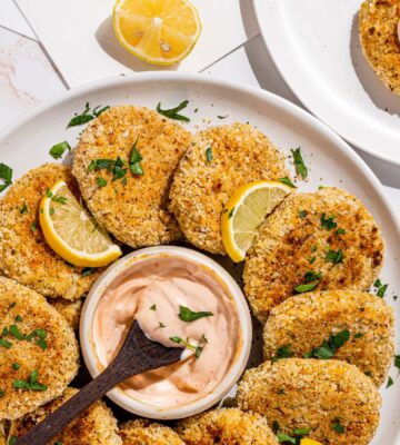 a picture of a plate decorated with hearts of palm crab cakes with a vegan aioli in the middle