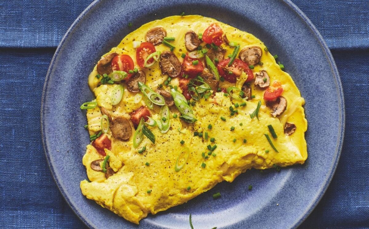 a picture of a vegan omelette folded in half with mushrooms and tomato