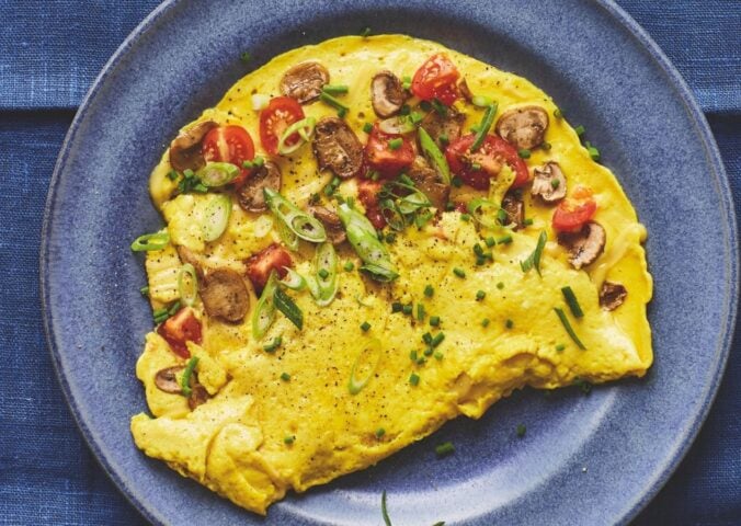 a picture of a vegan omelette folded in half with mushrooms and tomato