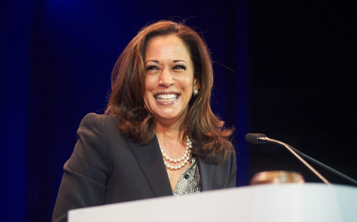 Democratic presidential nominee Kamala Harris standing at a podium and smiling