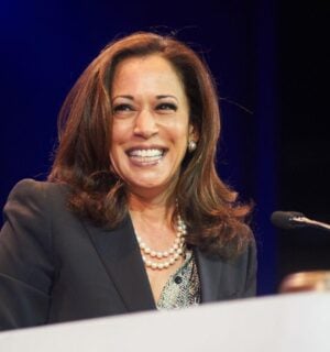 Democratic presidential nominee Kamala Harris standing at a podium and smiling