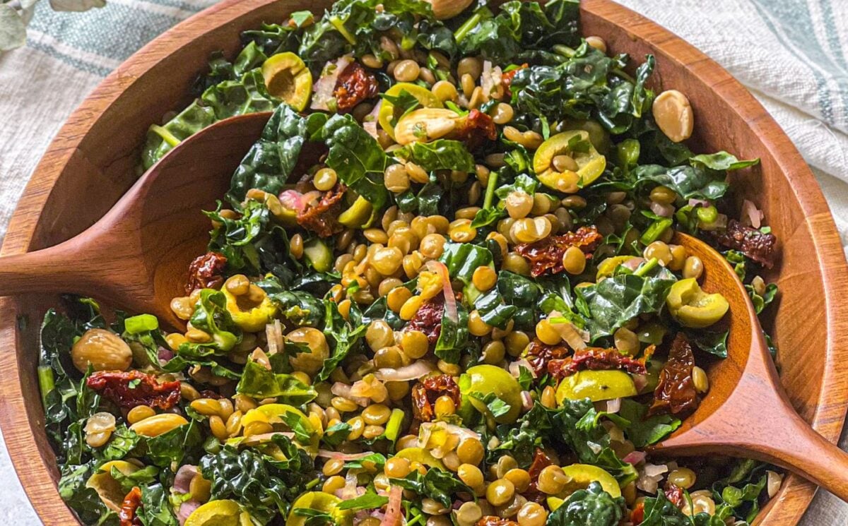 a picture of a lemon and pesto lentil salad made with olives, sundried tomatoes, kale, and almonds