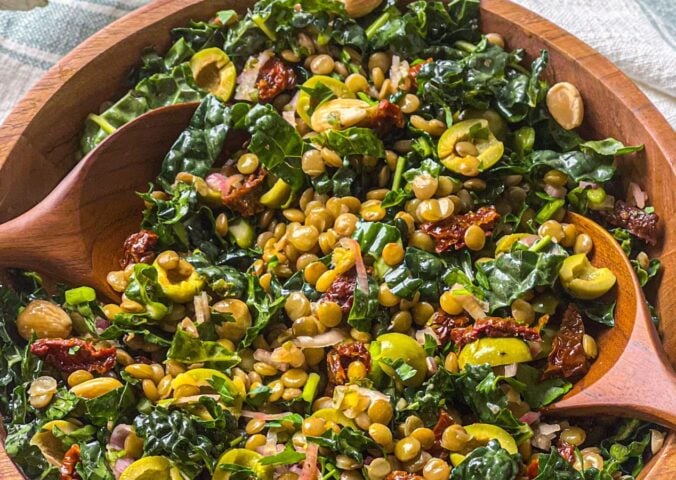 a picture of a lemon and pesto lentil salad made with olives, sundried tomatoes, kale, and almonds