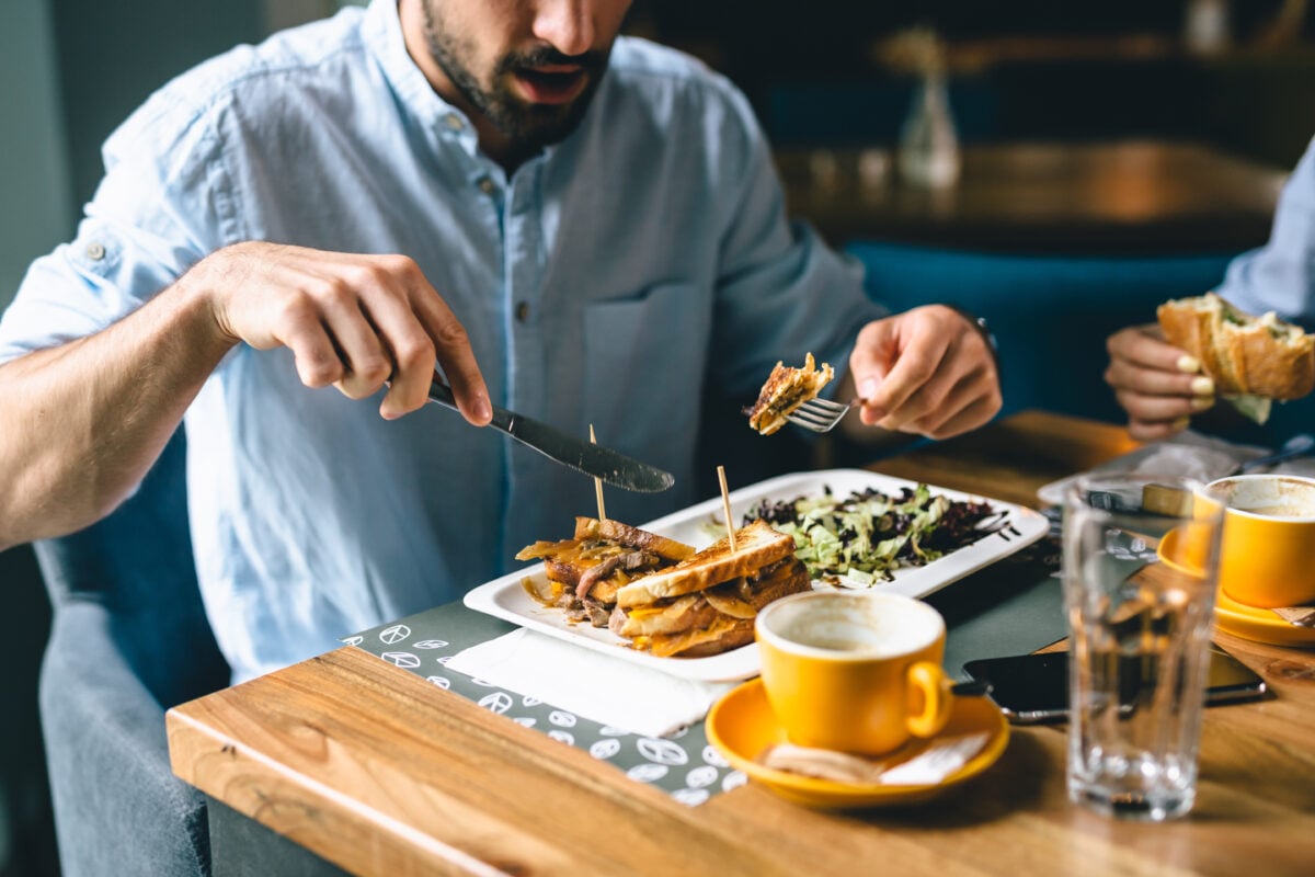 A man eating a grilled cheese sandwich in a restaurant