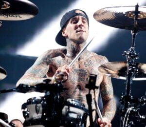 Photo shows vegan celebrity Travis Barker drumming for his band Blink 182