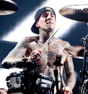 Photo shows vegan celebrity Travis Barker drumming for his band Blink 182