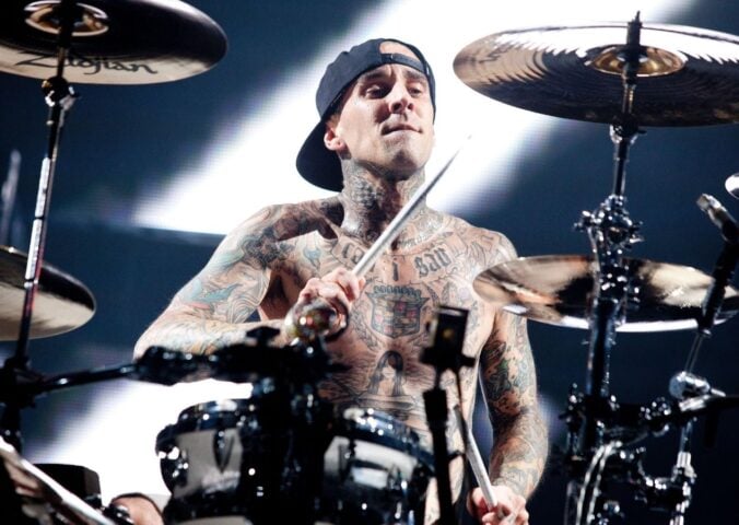 Photo shows vegan celebrity Travis Barker drumming for his band Blink 182