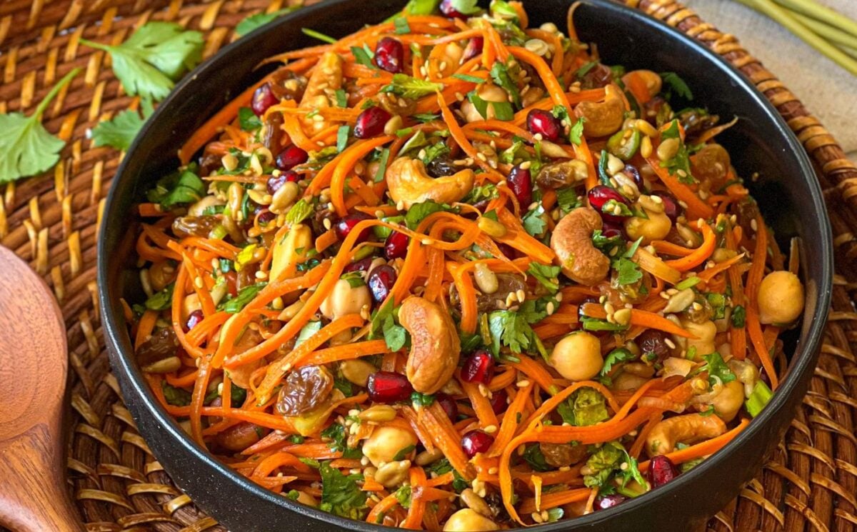 a picture of a moroccan carrot salad with citrust turmeric dressing made with chickpeas, cashews, orange juice, and more