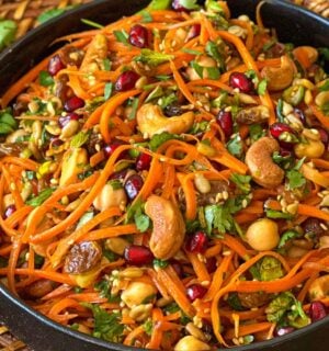 a picture of a moroccan carrot salad with citrust turmeric dressing made with chickpeas, cashews, orange juice, and more