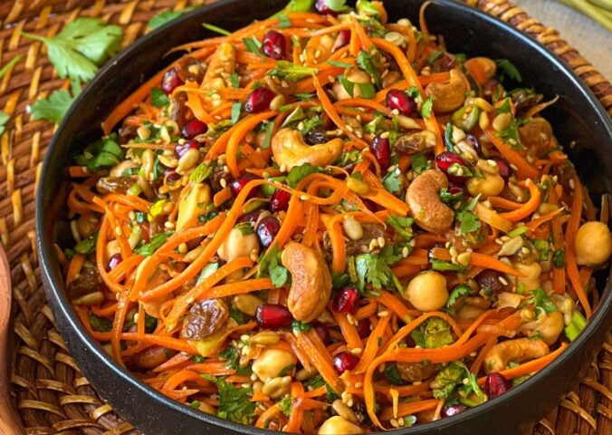 a picture of a moroccan carrot salad with citrust turmeric dressing made with chickpeas, cashews, orange juice, and more