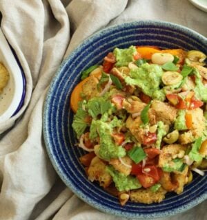 a picture of a panzanella pasta salad with croutons, tomato, onion, and plant-based feta