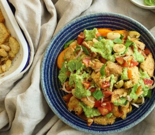 a picture of a panzanella pasta salad with croutons, tomato, onion, and plant-based feta