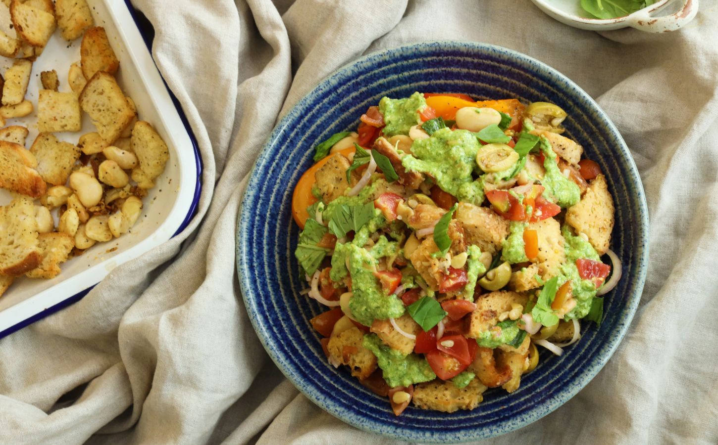 a picture of a panzanella pasta salad with croutons, tomato, onion, and plant-based feta