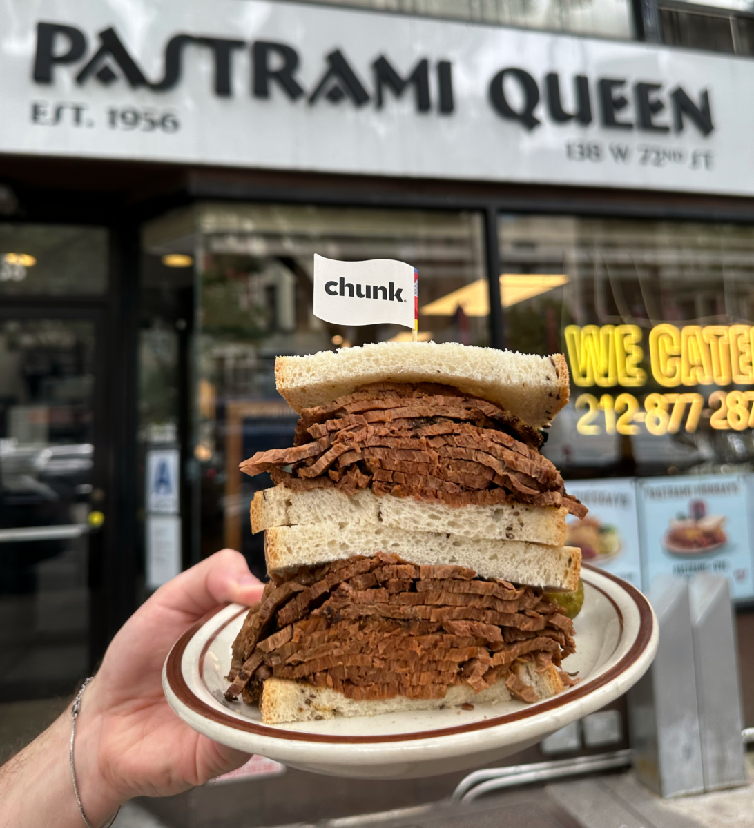 A person holding vegan sandwiches made with plant-based pastrami outside Pastrami Queen