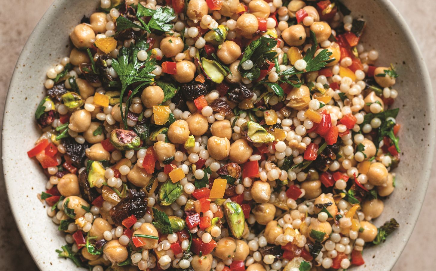 a picture of a pearl couscous and chickpea salad with preserved lemon, pepper, and other ingredients