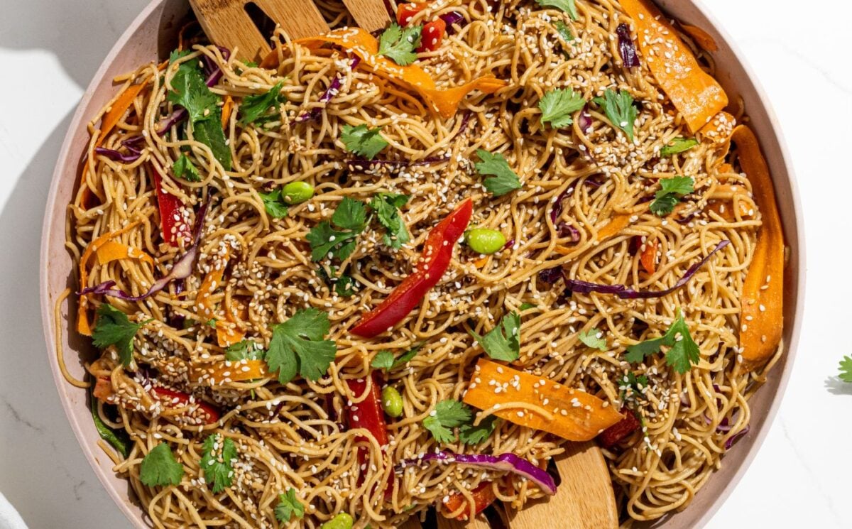 a picture of rainbow peanut noodles made with spinach, edamame, red bell pepper, and peanut sauce